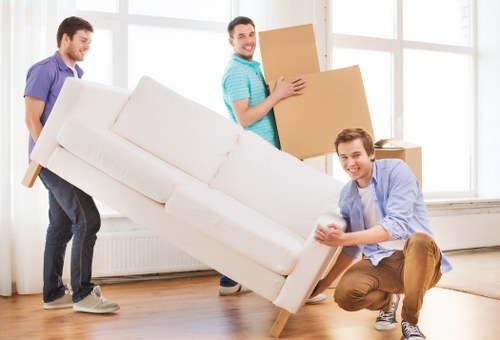Removal team preparing furniture for transport in Raynerslane